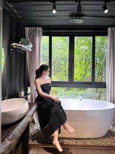 a woman sitting in a bath tub in a bathroom at YesHue Eco in Hue