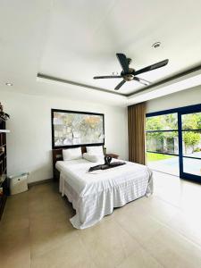 een slaapkamer met een bed en een plafondventilator bij Makati Walassey Villa in Karangasem