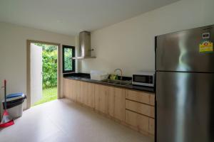 a kitchen with a stainless steel refrigerator at Viva Montane Hotel Pattaya in Pattaya South