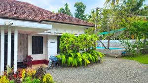a house with a bunch of plants in front of it at Mango Tree Villa in Unawatuna