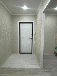 un pasillo con una puerta blanca en una habitación en Luxeroom, en Semey