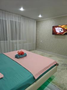 Un dormitorio con una cama con dos rosas rojas. en Luxeroom, en Semey