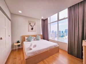 een slaapkamer met een bed en een groot raam bij Sky Suites KLCC Kuala Lumpur in Kuala Lumpur
