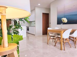 a dining room with a table and white chairs at Sky Suites KLCC Kuala Lumpur in Kuala Lumpur