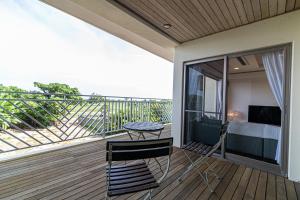 - un balcon avec un lit, une table et des chaises dans l'établissement Estrella Maezato - Vacation STAY 69423v, à Ōhama