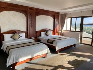 a hotel room with two beds and a window at Rex hotel An Nhon 