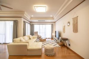 - un salon avec un canapé et une table dans l'établissement Estrella Maezato - Vacation STAY 69423v, à Ōhama