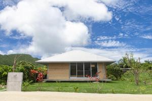 ein kleines Haus mit einem weißen Dach auf einem Rasen in der Unterkunft Oase Akaishi - Vacation STAY 69684v in Ibaruma