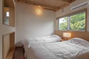 2 camas en una habitación pequeña con ventana en Oase Akaishi - Vacation STAY 69684v, en Ibaruma