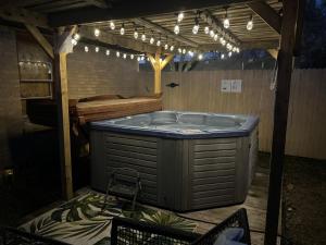 Luxury Oasis- 1 bedroom romantic getaways في لوبوك: حوض استحمام ساخن في الهواء الطلق في غرفة مع أضواء