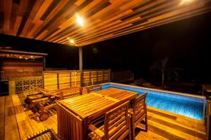 um pátio com mesas de madeira e uma piscina em OASE HOSHINO KAJI - Vacation STAY 75398v em Tōzato