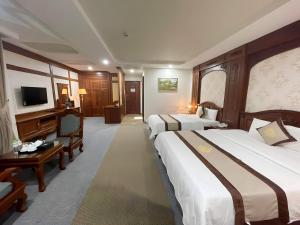 ein Hotelzimmer mit 2 Betten und einem TV in der Unterkunft Rex hotel An Nhon 