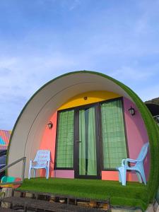 una casa con dos sillas sentadas fuera de ella en Cameron Highlands Blueberry Earth House en Cameron Highlands