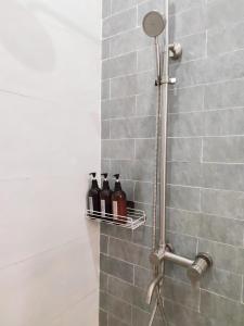 a shower with three bottles on a shelf in a bathroom at Ngày Tháng 5 - MayDay in Da Lat