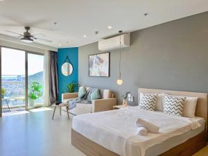 ブンタウにあるSóng Xanh Homestay - The Sóng Vũng Tàuのベッドルーム(大型ベッド1台付)、リビングルームが備わります。