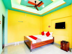 a bedroom with a bed with yellow walls and a ceiling at Dreams Inn in Kolkata