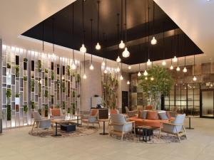 a lobby with couches and chairs and potted plants at La'gent Stay Shin Sapporo in Sapporo