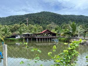 a house on a pier over a body of water at Vienna home 2 bedrooms+1 workroom for family in Pantai Cenang