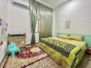 een slaapkamer met een bed en een blauwe stoel bij Vienna home 2 bedrooms+1 workroom for family in Pantai Cenang