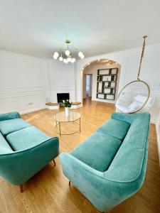 Private building - Apartment في بيستريتسا: غرفة معيشة مع كنبتين زرقاوين وطاولة