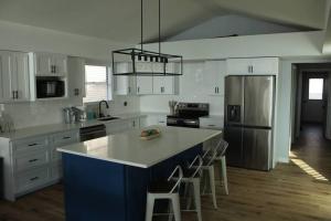 a kitchen with white cabinets and a blue island in a kitchen at Grand Glaize Getaway - Hot Tub, Dock, Firepit in Osage Beach
