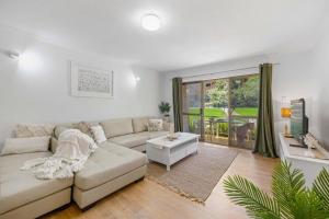 Sala de estar blanca con sofá y mesa en Shelly Cove Apt 12 - common pool, en Port Macquarie