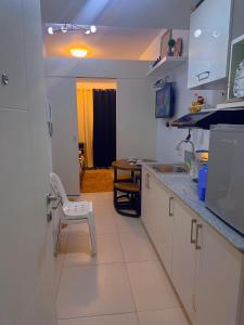a kitchen with a sink and a chair in it at SMDC coolsuites by Maryanne's staycation in Tagaytay