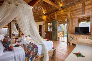 una camera con 2 letti e una TV a schermo piatto di The Meranggi ad Ubud