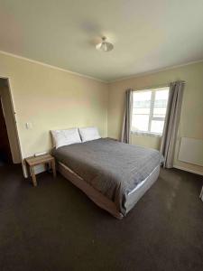 a bedroom with a large bed and a window at Town Centre Retreat in Taupo