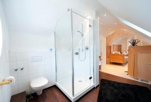 a bathroom with a shower with a toilet and a bedroom at Hotelpension Vitalis in Bad Hersfeld +43 photos