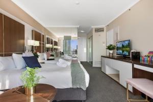 a hotel room with two beds and a television at Comfy Surfers Paradise Studio with Ocean View in Gold Coast