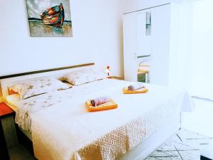 sypialnia z łóżkiem z dwoma ręcznikami w obiekcie Apartmani Maestral Fabijanić w mieście Pag