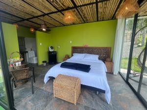 1 dormitorio con cama y pared verde en Glamping ríos voladores en Pereira