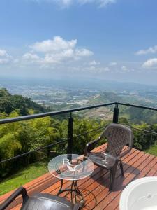 a table and a chair on a deck with a view at Glamping ríos voladores in Pereira