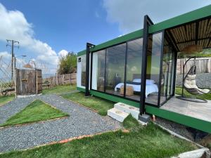 una casa de cristal verde con una cama en ella en Glamping ríos voladores en Pereira