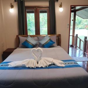 a towel in the shape of a heart on a bed at Walk in homestay in Ko Kood