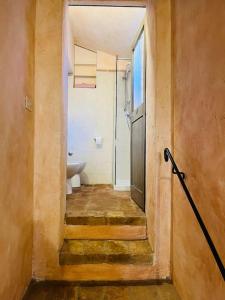 een hal van een badkamer met een toilet en een wastafel bij Appartamento nel castello del cardaneto in Montone