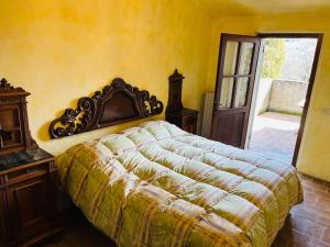 een slaapkamer met een bed in een gele muur bij Appartamento nel castello del cardaneto in Montone