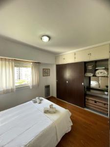 Un dormitorio con una gran cama blanca y una ventana en La Plata Housing I en La Plata