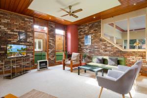 a living room with a brick wall at Spacious 3-Bed Mid Century Home Near CBD in Sydney