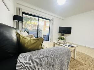 a living room with a couch and a television at 2 Paradise Pool Parking Huge 1br Cbd in Perth