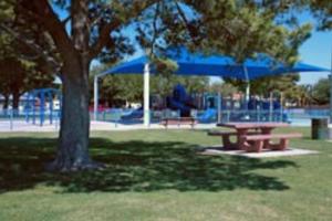 ein Picknicktisch und blaue Sonnenschirme in einem Park in der Unterkunft Casa Rio spacious 3 bd/ 3.5 bath near airport in Las Vegas