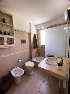 a bathroom with a toilet and a sink and a tub at La Plata Housing I in La Plata