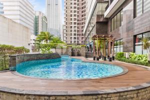 a large swimming pool in the middle of a city at Gratia by Kozystay - 1BR - City View - Kuningan in Jakarta