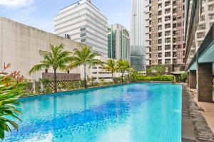 a swimming pool in a city with tall buildings at Gratia by Kozystay - 1BR - City View - Kuningan in Jakarta