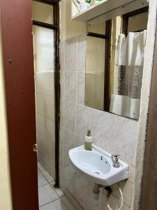 a bathroom with a sink and a mirror at Machakos Town Coffee Residencies in Machakos