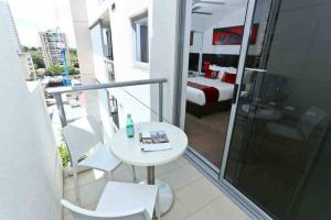 Un balcón con mesa y sillas y un dormitorio. en Central CBD Studio, Balcony, Pool, Gym, Sauna, en Brisbane