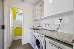 a kitchen with a sink and a washing machine at The Entertainer in Perth