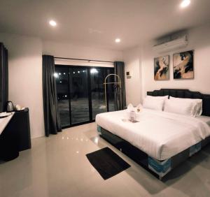 una camera con un letto e una grande finestra di Skybird lake view Resort&Camping Khaoyai a Khanong Phra