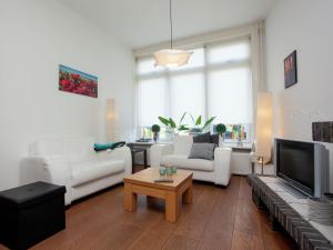 a living room with white furniture and a large window at Holiday Home in Alkmaar by Canal in Alkmaar
